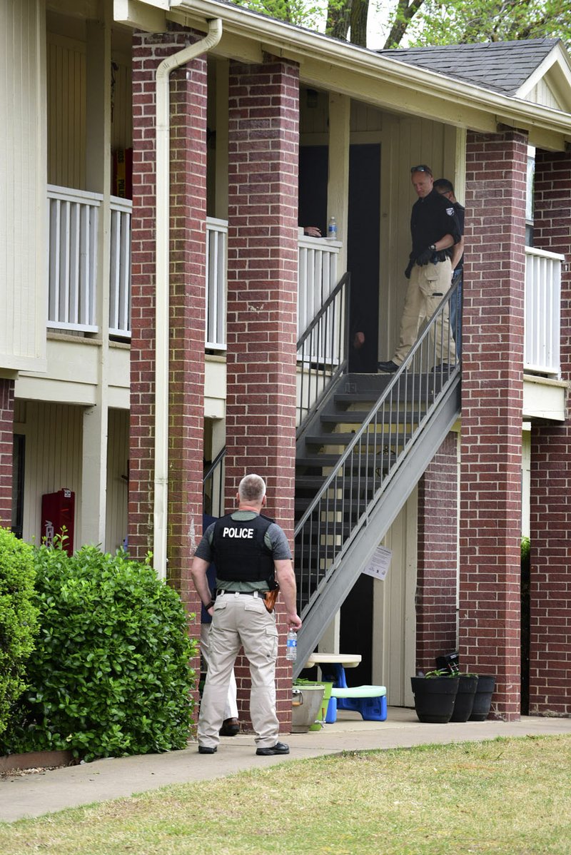 NWA Democrat Gazette/SPENCER TIREY Little Flock police officers and Benton County Sheriffs deputies talk outside an apartment in the Fairways at Lost Springs Apartments complex after two people were shot early Friday morning.