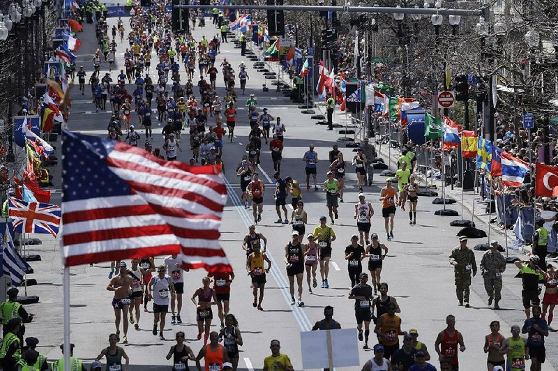 Runners head down the stretch toward the fi nish line during the 121st Boston Marathon on Monday. Temperatures reached the mid- 70s, which made it a little more difficult for participants to complete the 26.2-mile course.