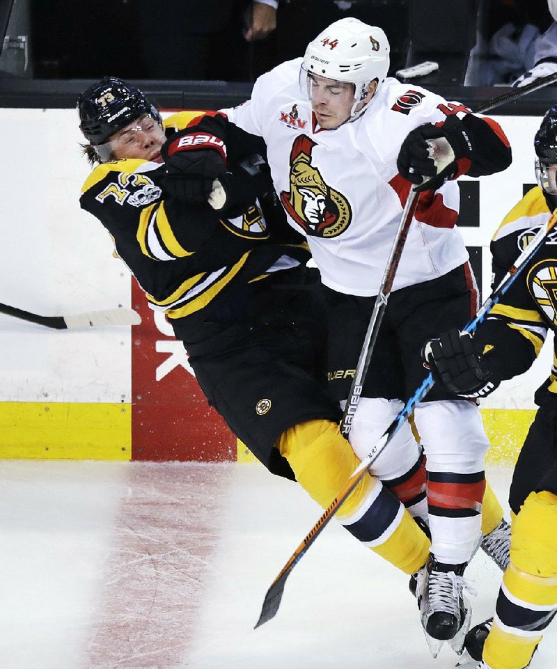 Ottawa center Jean-Gabriel Pageau (right) drops Boston defenseman Charlie McAvoy to the ice on a hard check during the first period in Game 3 of their NHL Eastern Conference playoff matchup Monday. The Senators got a goal from Bobby Ryan in overtime to beat the Bruins 4-3 and take a 2-1 series lead.