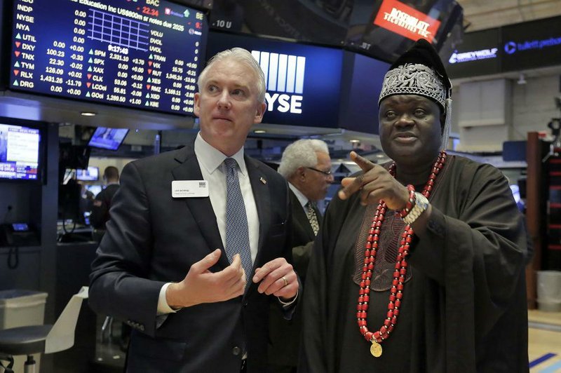 King Michael Odunayo Ajayi of Nigeria’s Osun state is escorted Monday by Jim Byrne, the New York Stock Exchange’s head of U.S. listings, during a visit to the trading floor.
