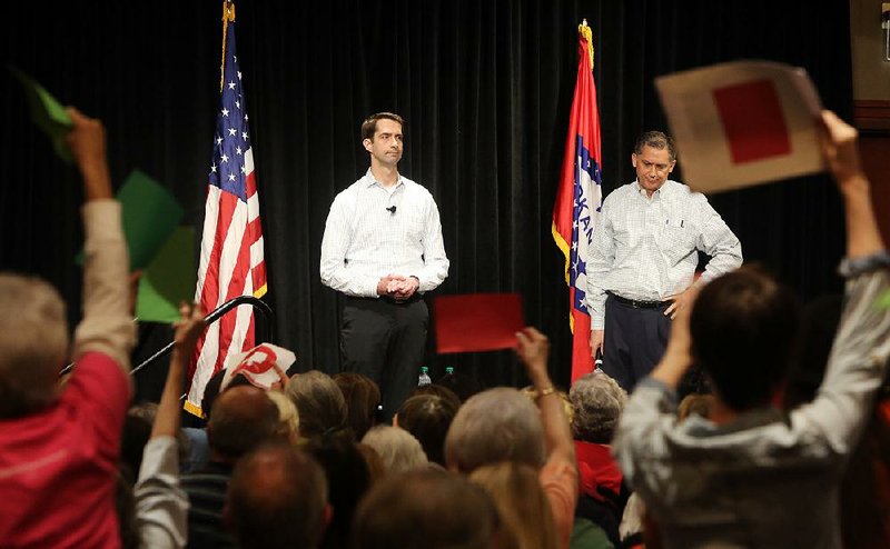 U.S. Sen. Tom Cotton (left) and U.S. Rep. French Hill fi eld questions from an audience of 1,000 people at a public meeting Monday in west Little Rock. Some in the crowd were angry over recent actions by Congress and the president, but other people expressed support.