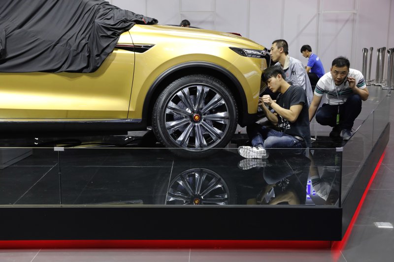 Workers prepare for the Auto Shanghai 2017 show at the National Exhibition and Convention Center in Shanghai, China, Tuesday, April 18, 2017. At the auto show, the global industry's biggest marketing event of the year, almost every global and Chinese auto brand is showing at least one electric concept vehicle, if not a market-ready model. (AP Photo/Ng Han Guan)

