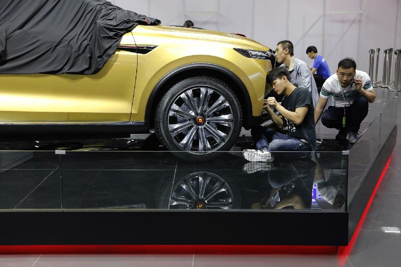 Chinese workers prepare for the Shanghai auto show at the city’s National Exhibition and Convention Center on Tuesday.