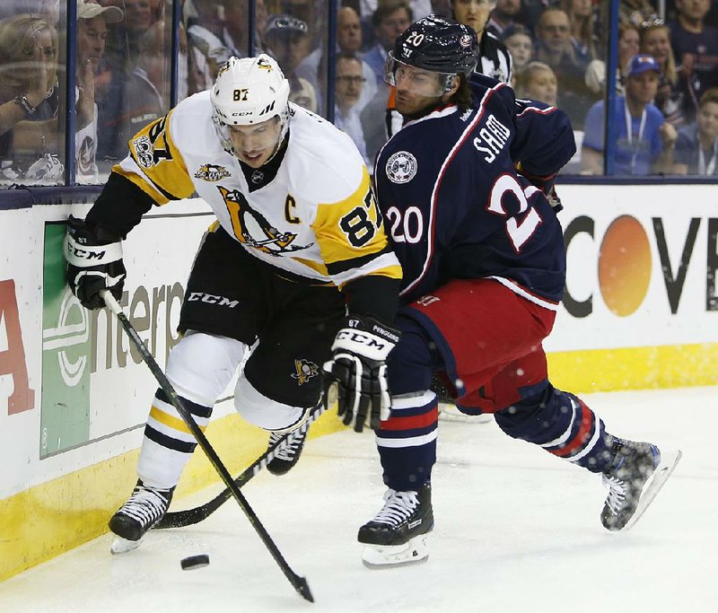 Pittsburgh’s Sidney Crosby (left) battles with Columbus’ Brandon Saad to control the puck during Tuesday night’s game. The Blue Jackets avoided elimination with a 5-4 victory in Game 4 of their NHL Eastern Conference playoff series.