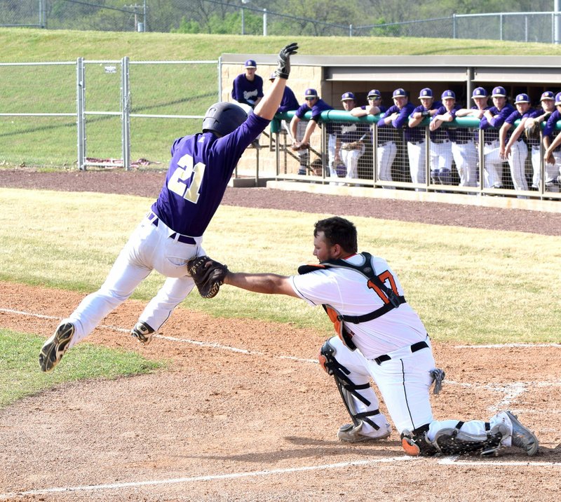 Photo by Mike Eckels Thomas Trowbridge (Berryville 21) tried to leap out of the way of Kenton Tajchman&#8217;s (Gravette 17) glove during the Lion-Bobcat baseball contest at Gravette High School baseball field in Gravette April 14. Trowbridge was tagged out by Tajchman for a Berryville out.