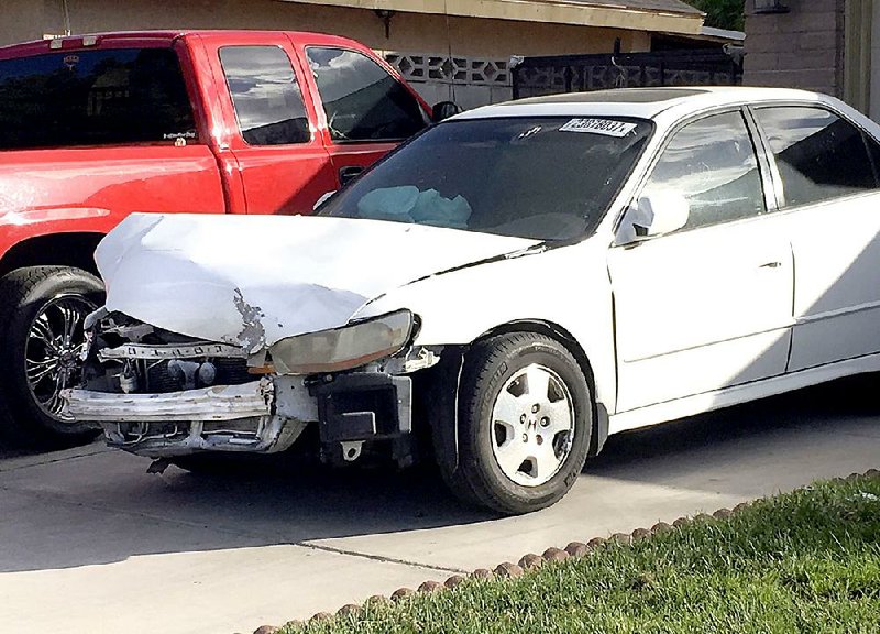 Karina Dorado’s white Honda Accord, damaged in a wreck in March, is parked in a driveway in Las Vegas on Tuesday. Dorado was injured when the salvaged airbag in the car exploded during the wreck. 