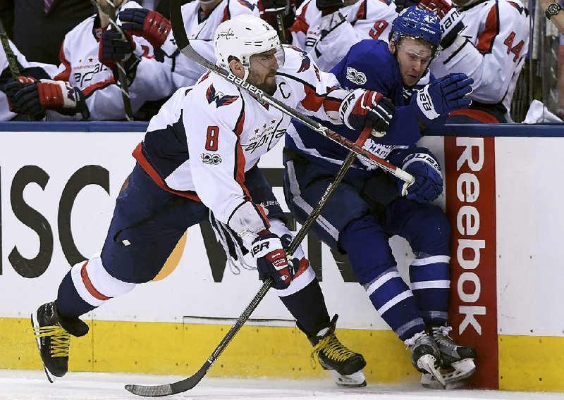 Washington left wing Alex Ovechkin (left) sends Toronto center Tyler Bozak into the railing during the second period of Wednesday’s game. The Capitals evened up their NHL Eastern Conference playoff series at 2-2 with a 5-4 victory behind two goals from right wing Tom Wilson.