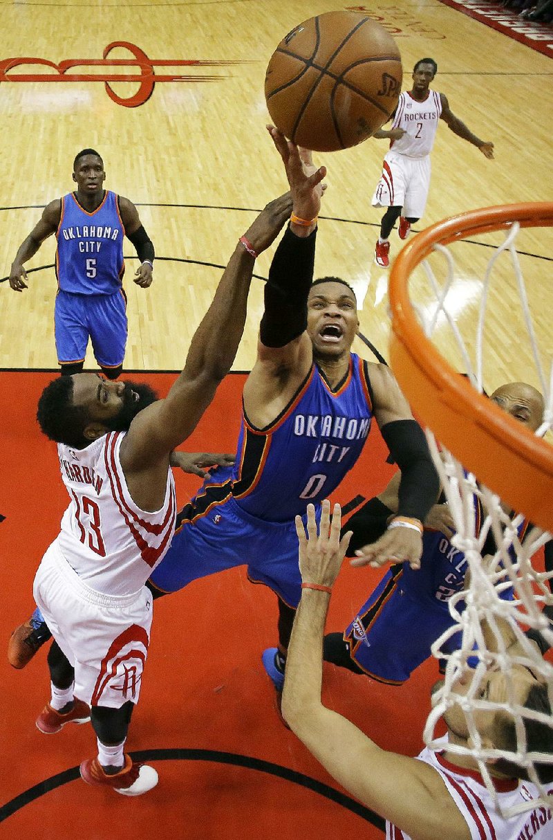 Oklahoma City guard Russell Westbrook (right) gets to the rim past Houston guard James Harden during the second half of Wednesday’s game. Westbrook finished with 51 points, 13 assists and 10 rebounds, but the Rockets surged ahead in the fourth quarter to beat the Thunder 115-111 and grab a 2-0 lead in their NBA Western Conference playoff series.