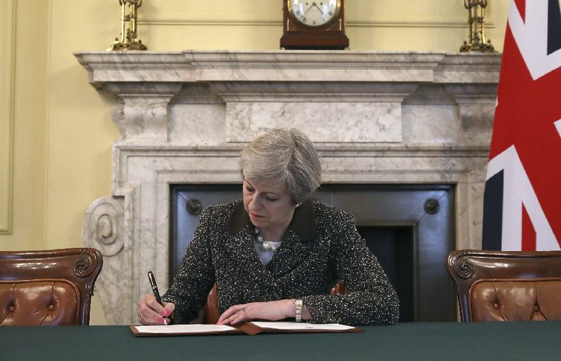 British Prime Minister Theresa May in March signs the official letter to European Council President Donald Tusk invoking the formal start of European Union exit negotiations.