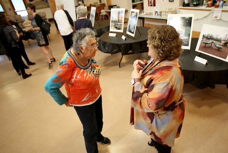 NWA Democrat-Gazette/DAVID GOTTSCHALK Betty Christian (left) speaks Wednesday with Kelly Colebar, Fayetteville Community Resources Division community resources administrator, during a reception at the Fayetteville Senior Activity and Wellness Center. The division hosted the reception to display the different programs the Community Development Block Grant helps. The reception also coincides with National Community Development Week.