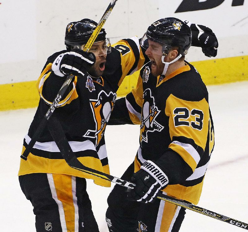 Pittsburgh’s Scott Wilson (right), celebrates his goal with Trevor Daley during the third period in Game 5 of an NHL Eastern Conference playoff series against Columbus on Thursday. The Penguins pulled away to eliminate the Blue Jackets 5-2.