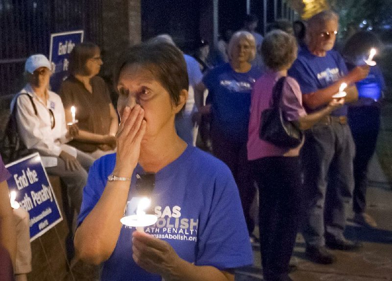 Suzanne Ritchie and other members of the Arkansas Coalition to Abolish the Death Penalty hold a vigil Thursday night outside the Governor’s Mansion in Little Rock in opposition to the scheduled execution of Ledell Lee. Ritchie said she taught Marcel Williams, who is scheduled to be executed Monday, in junior high school.