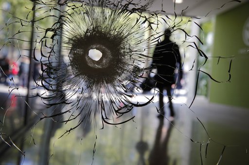 A bullet hole is pictured on a shopwindow of the Champs Elysees boulevard in Paris on Friday, April 21, 2017. 