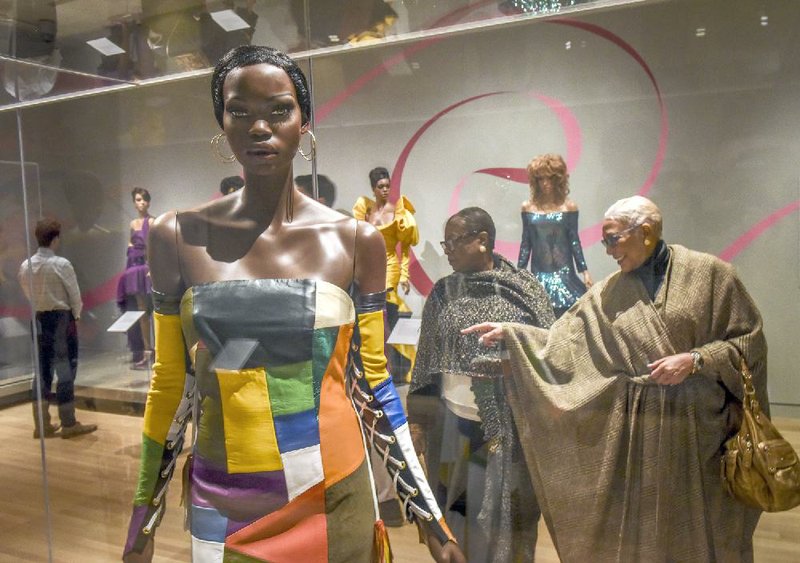 Guests examine a mannequin adorned in a leather patchwork evening gown by L’Amour Ameer at the launch of “Inspiring Beauty: 50 Years of Ebony Fashion Fair” exhibition March 31 in Washington. 