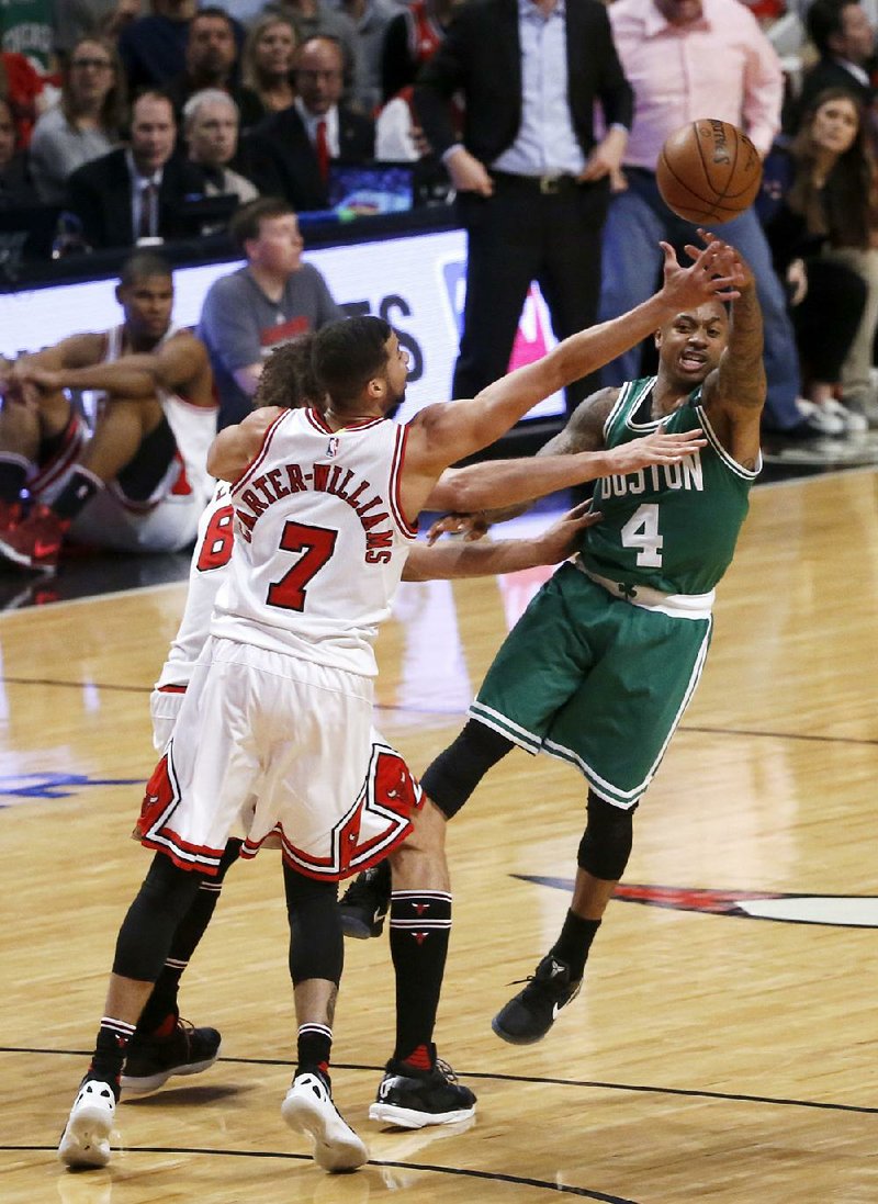 Isaiah Thomas (right) of the Boston Celtics passes under pressure from Michael Carter-Williams (7) and Robin Lopez of the Chicago Bulls during Friday’s NBA Eastern Conference playoff game. Boston won 104-87 and trails 2-1 in the series.