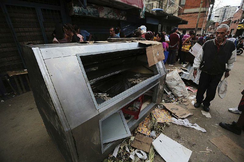 A destroyed refrigerator sits in the street Friday after a night of violence and looting in Caracas, Venezuela.