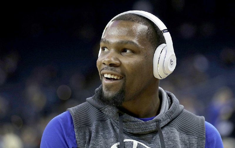 Golden State Warriors' Kevin Durant smiles as he warms up before the team's NBA basketball game against the New Orleans Pelicans on Saturday, April 8, 2017, in Oakland, Calif.