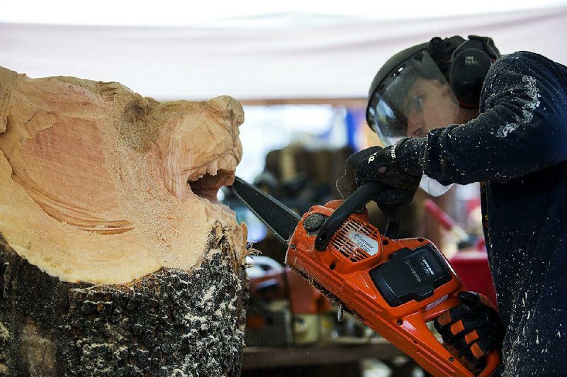 Steve Higgins of Kansas City, Mo., works on a piece Friday during the 13th annual Carving in the Ozarks in Eureka Springs. 