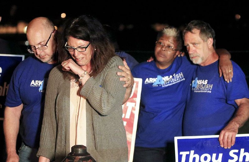 Abe Bonowitz comforts Lynn Scott (second from left) outside the Cummins Unit during a vigil with Judy Johnson, Randy Gardner and other protesters shortly after all of the stays for Ledell Lee’s execution were exhausted late Thursday.