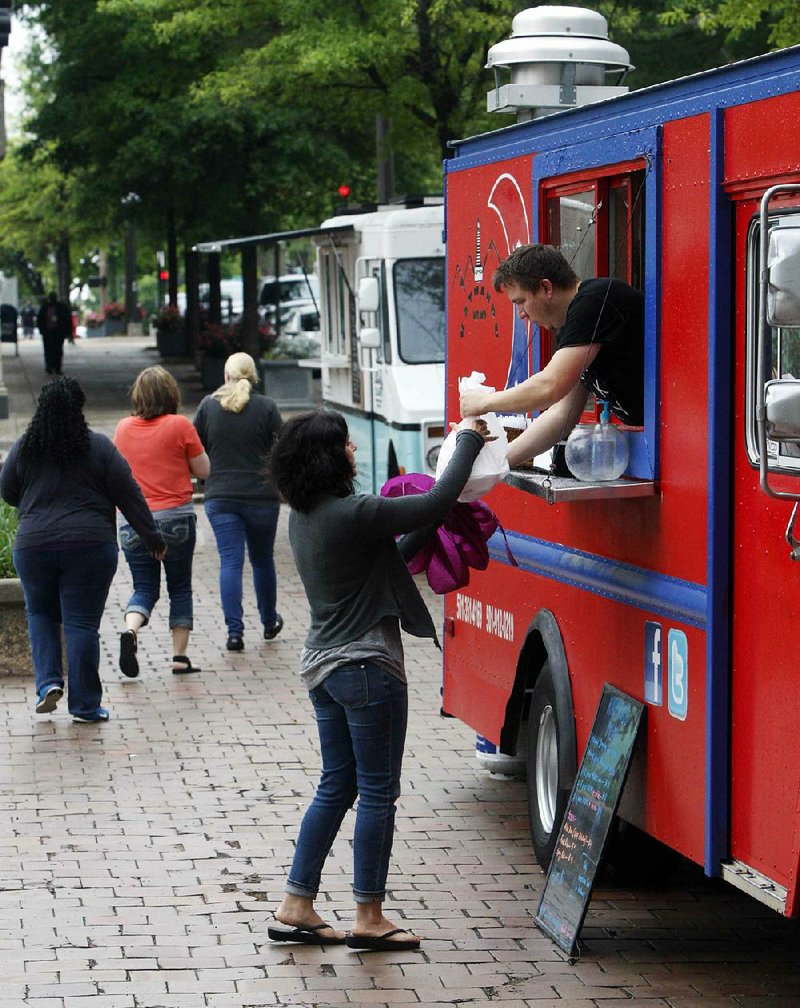 Arkansas Democrat-Gazette/JEFF MITCHELL - 04/21/2016  - Brandy McNair gets her order from food truck operator Kyler Nordeck on the opening Friday of this year's Main Street food truck Fridays at Main Street and Capitol Avenue in downtown Little Rock, April 21, 2017. The Friday-only event will end June 23.
