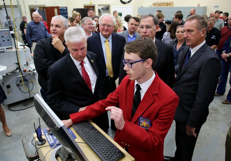 NWA Democrat-Gazette/DAVID GOTTSCHALK Cayden Hollingsworth (center), a junior at Har-Ber High School, describes the operation of a CNC machine Friday to 3rd District Rep. Steve Womack (left) during a tour of a section of the new mechanical lab at the Springdale school. Northwest Arkansas dignitaries, school officials and the public toured the new facility to that will house construction technology programs.