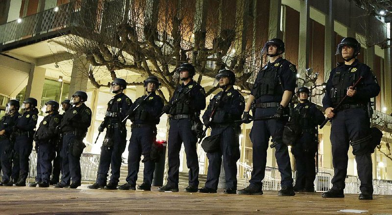 Police officers stand guard Feb. 1 at the University of California, Berkeley, outside the building where right-wing writer Milo Yiannopoulos was scheduled to speak, before a violent outbreak forced the cancellation of his event. 