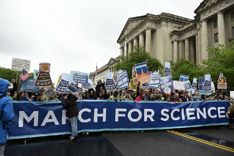 A March for Science crowd passes the Environmental Protection Agency offices Saturday in Washington in one of many Earth Day events around the world in support of science, scientists and scientific facts.