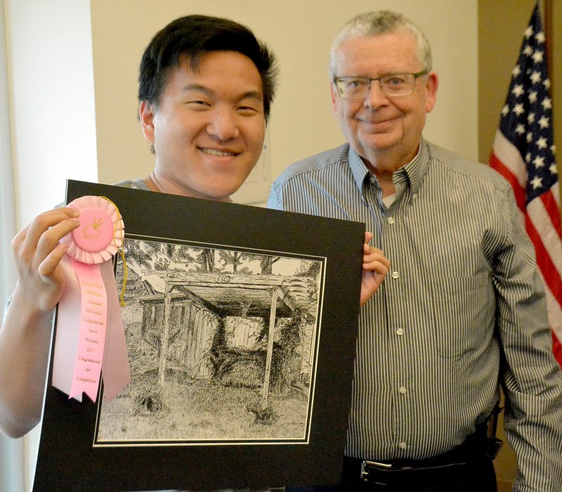 Janelle Jessen/Siloam Sunday Matthew Cha, a junior at Siloam Springs High School, and art teacher Ken Francis posed with the fourth place award Cha received for his pen and ink drawing in the Third Congressional District Art Competition.