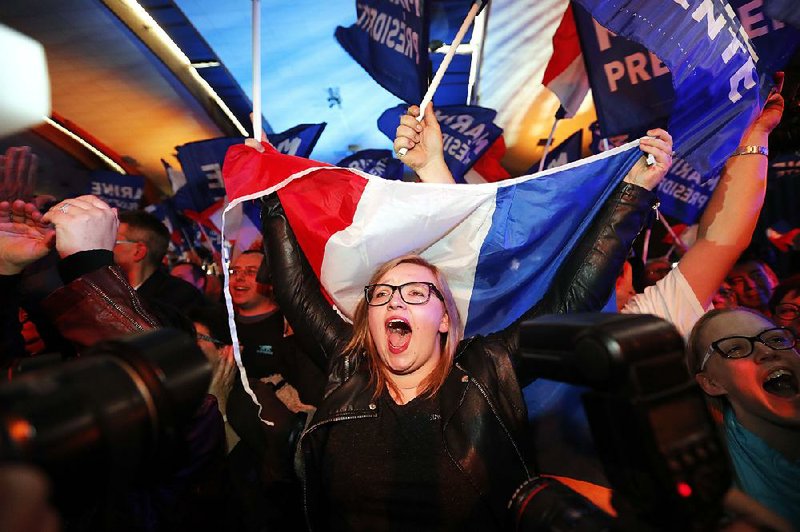 Supporters of far-right leader and French presidential candidate Marine Le Pen celebrate after exit-poll results of the first round of voting are announced at election day headquarters Sunday in Henin-Beaumont, northern France.