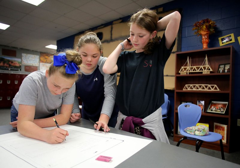 Kylee Dunn (from left), Emma Evans and Alyssa Wilson, all sixth-graders at Sonora Middle School, work on an antibullying project Friday during the lunch hour at the school. A focus on providing students with a personalized learning environment supported by technology has resulted in Principal Martha Dodson seeing an increase in students who ask for passes to work on projects during lunch.