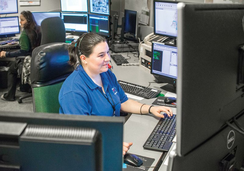 Conway dispatcher Alex Stoecker enters information at a workstation in the Conway Emergency Operations Center, which the city and Faulkner County share. A 911 working group is looking at how to combine the two dispatching systems and fund an emergency-system upgrade that is due in August.  The upgrade is estimated to cost at least $600,000.