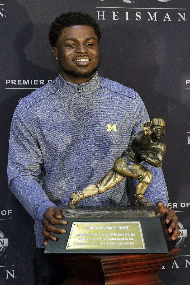 Heisman Trophy finalist from Michigan Jabrill Peppers, poses with the award in New York, Friday, Dec. 9, 2016. 