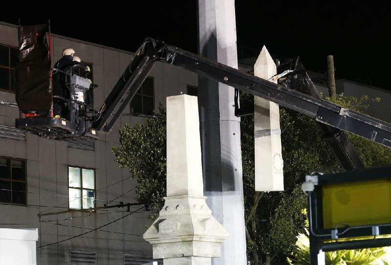 Workers early Monday dismantle the Liberty Place monument, which commemorates a post-Civil War battle in which white supremacists fought New Orleans’ mixed-race police force in an attempt to overthrow the city’s government.