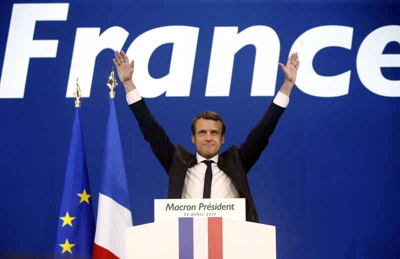 FILE - In this Sunday April 23, 2017 file photo, French centrist presidential candidate Emmanuel Macron waves before addressing his supporters at his election day headquarters in Paris. They could hardly be more different: Pro-European centrist Emmanuel Macron is facing anti-immigration, anti-EU Marine Le Pen in France's presidential runoff May 7. 