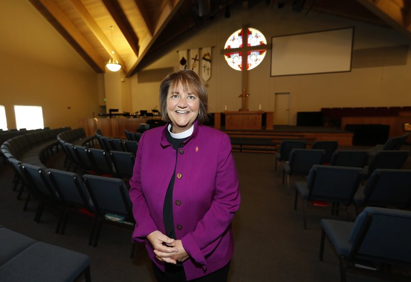 In this Wednesday, April 19, 2017, photo, Bishop Karen Oliveto poses for a photo in the sanctuary of a United Methodist Church in Highlands Ranch, Colo. The top court in the United Methodist Church on Tuesday, April 25, will consider whether the election of Oliveto, the first openly lesbian Methodist bishop, violated church law barring clergy who are ``self-avowed practicing homosexuals.&#x2019;&#x2019; (AP Photo/David Zalubowski)