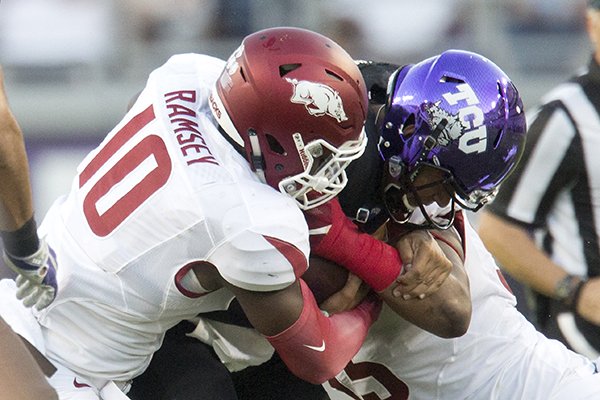 TCU junior quarterback Kenny Hill is stopped for a loss by Arkansas sophomore defensive end Randy Ramsey (left) and senior defensive linemen Jeremiah Ledbetter on Saturday, Sept. 10, 2016, at Amon G. Carter Stadium in Fort Worth, Texas.

