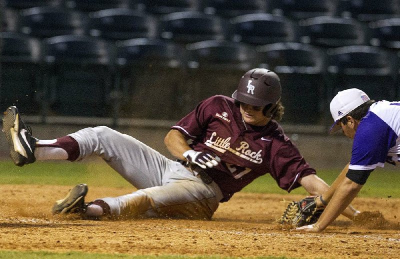 UALR baserunner Riley Pittman slides across home plate past UCA pitcher Will Brand to score in Tuesday night’s game at Dickey-Stephens Park in North Little Rock. The Trojans beat the Bears 11-6 to avenge a 12-3 loss to their in-state rivals on March 14.