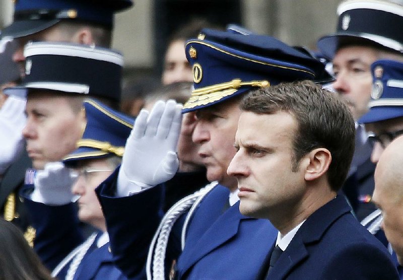 French centrist presidential candidate Emmanuel Macron attends a ceremony for slain police officer Xavier Jugele, in the courtyard of the Paris Police headquarters, Tuesday, April 25, 2017.