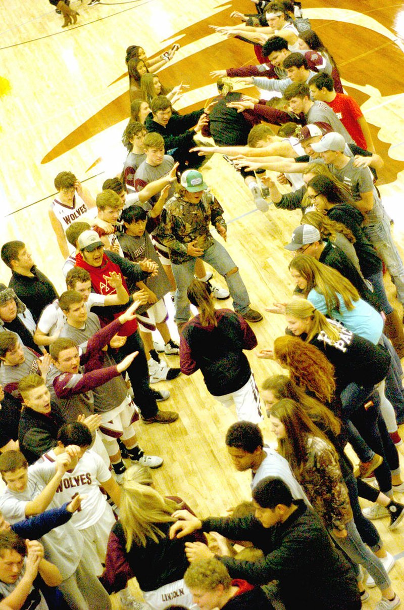 MARK HUMPHREY ENTERPRISE-LEADER Lincoln varsity girls basketball players come out onto the court greeted by enthusiastic fans in the spirit line.