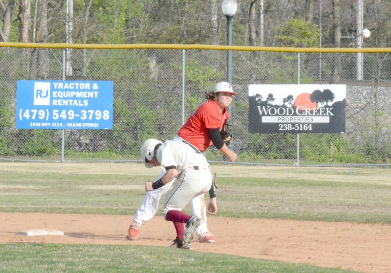 GRAHAM THOMAS HERALD-LEADER Farmington second baseman Blake Putnam makes the throw to first base as Siloam Springs courtesy runner Nolan Wallis ducks out of the way during an April 7 game won 4-0 by Farmington. The Cards lost 9-7 at home to Harrison April 3.