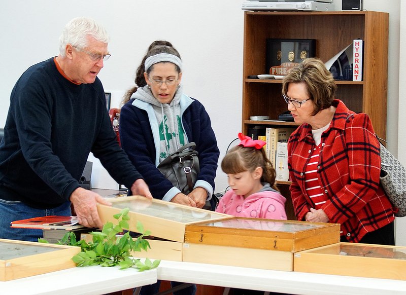 Photo by Randy Moll University of Arkansas professor Don Steinkraus shows boxes of butterflies and moths to Melinda Crawley and Yvonne Larson and her granddaughter Eden at an Earth Day observance of the Eagle Watch Nature Trail which was held at the Gentry Fire Station on Saturday.