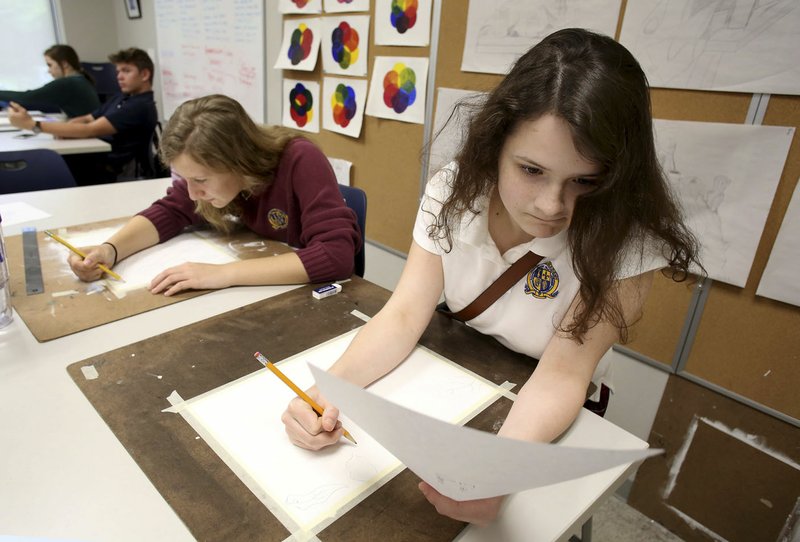 NWA Democrat-Gazette/DAVID GOTTSCHALK Eliza Osborne (from right), a junior at Haas Hall Academy, and Johanna Berryman, a senior, work Tuesday on a color scheme watercolor composition in Basil Seymour-Davies’ art class at the Starr Scholar Center in Fayetteville. The Fayetteville campus has been ranked as the top public high school in the state and is 60th in the nation by U.S. News & World Report.