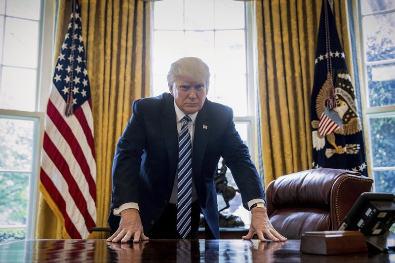 FILE - In this Friday, April 21, 2017, file photo, President Donald Trump poses for a portrait in the Oval Office in Washington. Trump will mark the end of his first 100 days in office with a flurry of executive orders as he looks to fulfill campaign promises and rack up victories ahead of that milestone. (AP Photo/Andrew Harnik, File)