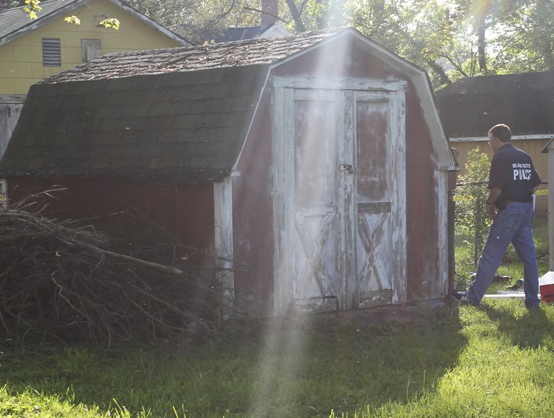 In this photo provided by the Blanchester Police Department, an officer walks near a shed owned by Dennis Dunn, who was arrested Wednesday, April 26, 2017, on a charge of kidnapping in Blanchester, Ohio. 