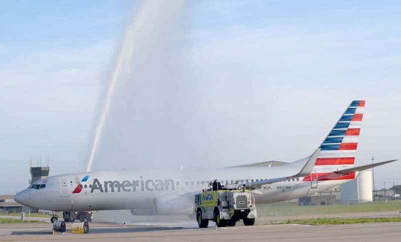 Two units from the Northwest Arkansas Regional Airport fire department shoot an arch of water over the chartered aircraft of the O&A Honor Flight as it taxied to runway 16 April 19 in Highfill. The arch is a time-honored tradition paying tribute to retiring or retired military personnel.