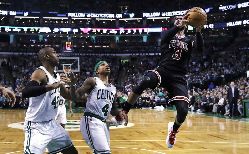 Chicago guard Dwyane Wade (right) shoots over Boston defenders Isaiah Thomas (center) and Al Horford in the second quarter of Wednesday’s game. Wade had 26 points, 11 rebounds and 8 assists, but the Celtics pulled away in the second quarter for a 108-97 victory in the NBA Eastern Conference playoffs.