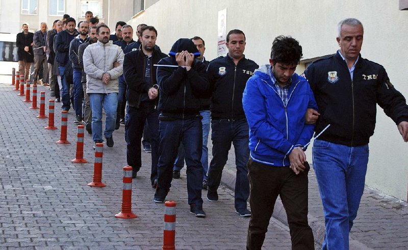 Detainees suspected of ties to U.S.-based cleric Fetullah Gulen are escorted by police officers Wednesday in Kayseri, Turkey. Police carried out simultaneous operations across the country on suspected followers of Gulen, whom officials blamed for a coup attempt in July. At least 1,013 people were detained and warrants for another 2,200 were issued, officials said.