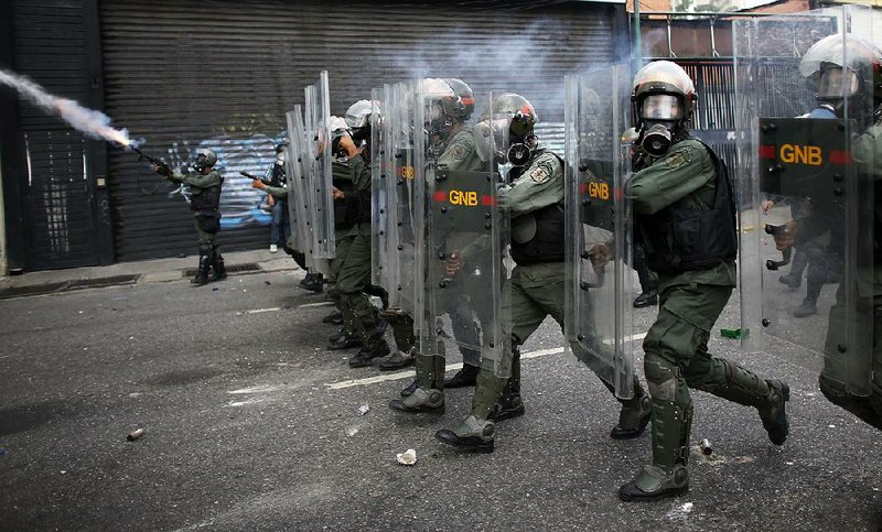 Members of the Bolivarian National Guard block protesters Wednesday in downtown Caracas, Venezuela. As protests persist against the government of President Nicolas Maduro, international pressure to schedule delayed regional elections and to free political activists has been mounting steadily at the Organization of American States and in other regional forums.