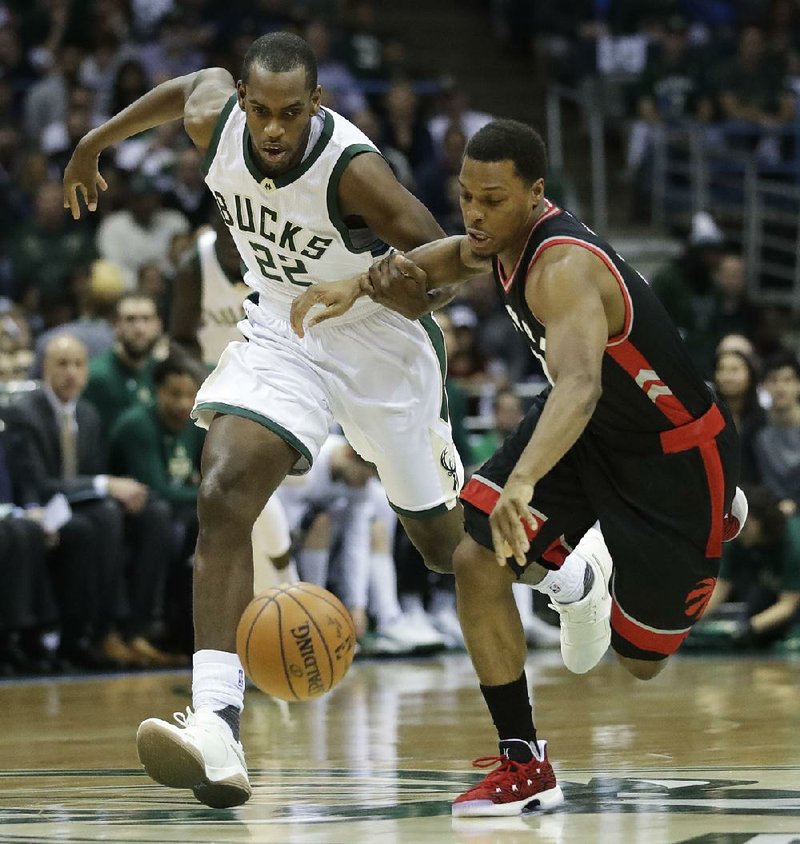 Milwaukee’s Khris Middleton (left) and Toronto’s Kyle Lowry chase down a loose ball during Game 6 of their NBA Eastern Conference playoff series Thursday. The Raptors blew a 25-point, third-quarter lead but battled back in the fourth quarter to beat the Bucks 92-89.