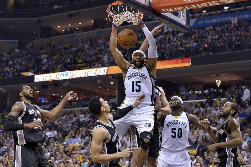 Memphis Grizzlies guard Vince Carter (15) dunks in two of his 12 points between San Antonio Spurs forward LaMarcus Aldridge and guard Danny Green in the Spurs 103-96 victory. San Antonio won the series 4-2 and will meet Houston in the second round.